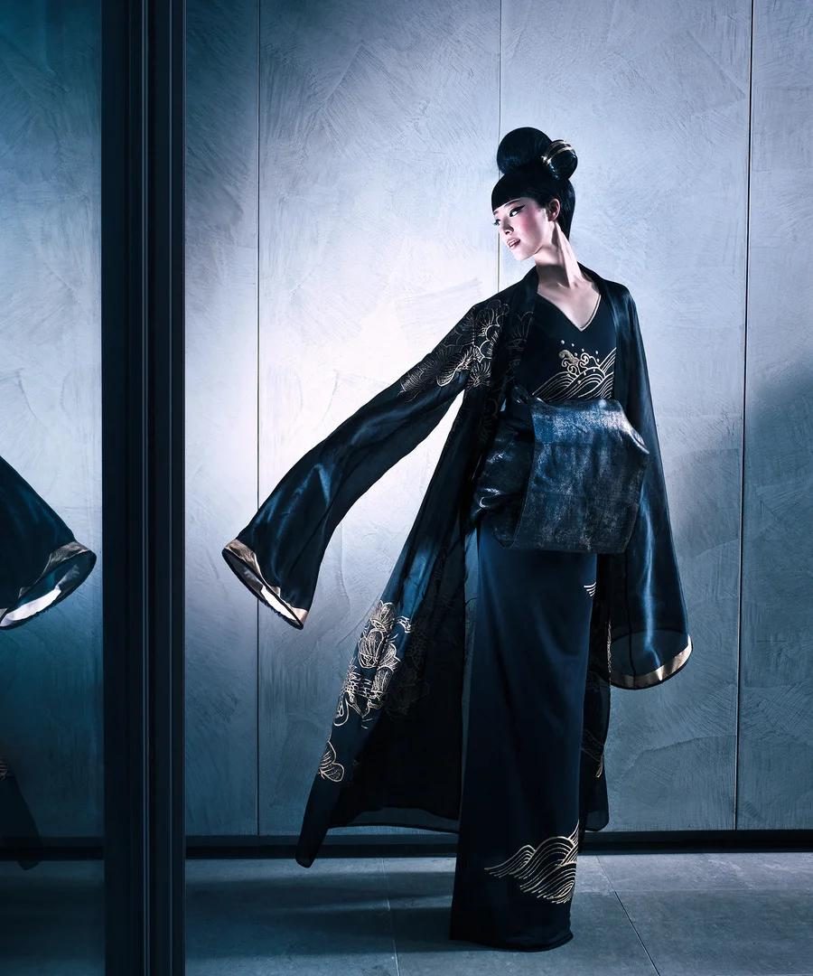 Black kimono with gold linework in an architectural, blue-lit interior